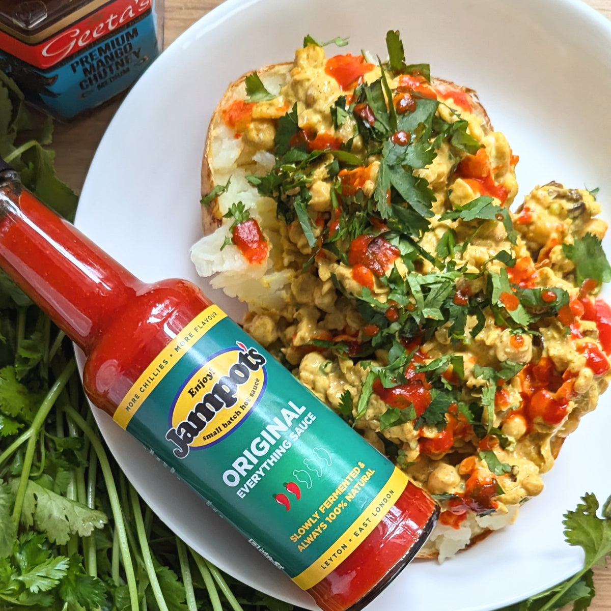 Jampot's fermented hot sauce drizzled on Coronation chickpea jacket potato.